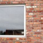 Modern picture window in a recycled brick exterior wall